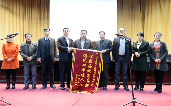 李磊为全体队员颁授青海省海北州送来的锦旗